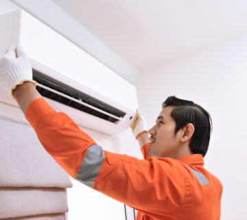 Teknisi AC sedang servis AC split di rumah pelanggan di Jakarta Utara